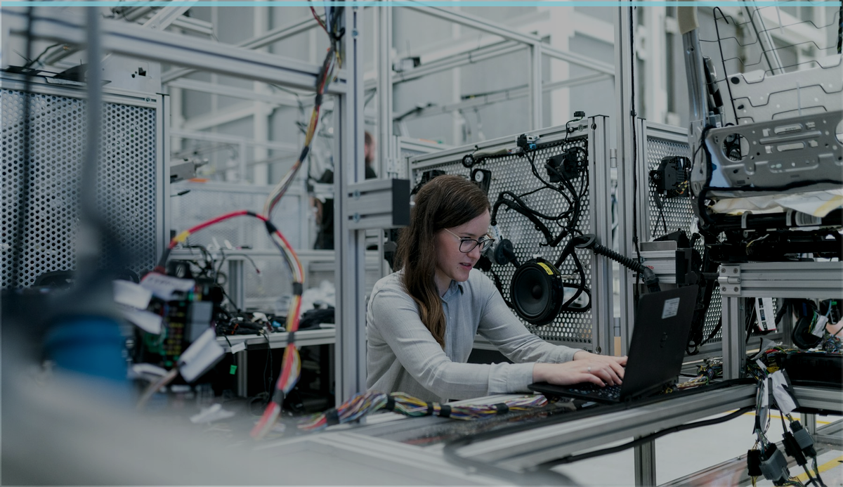 Engineer using a laptop inside a manufacturing environment