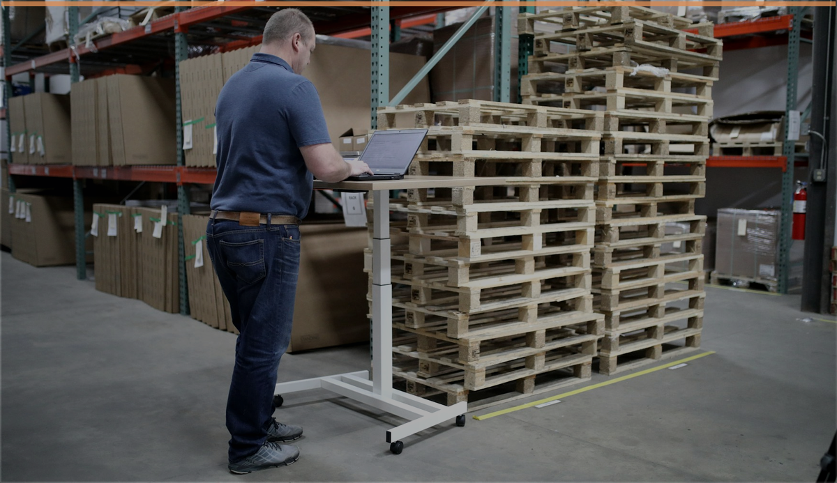 Warehouse worker using a laptop for e-commerce operations review